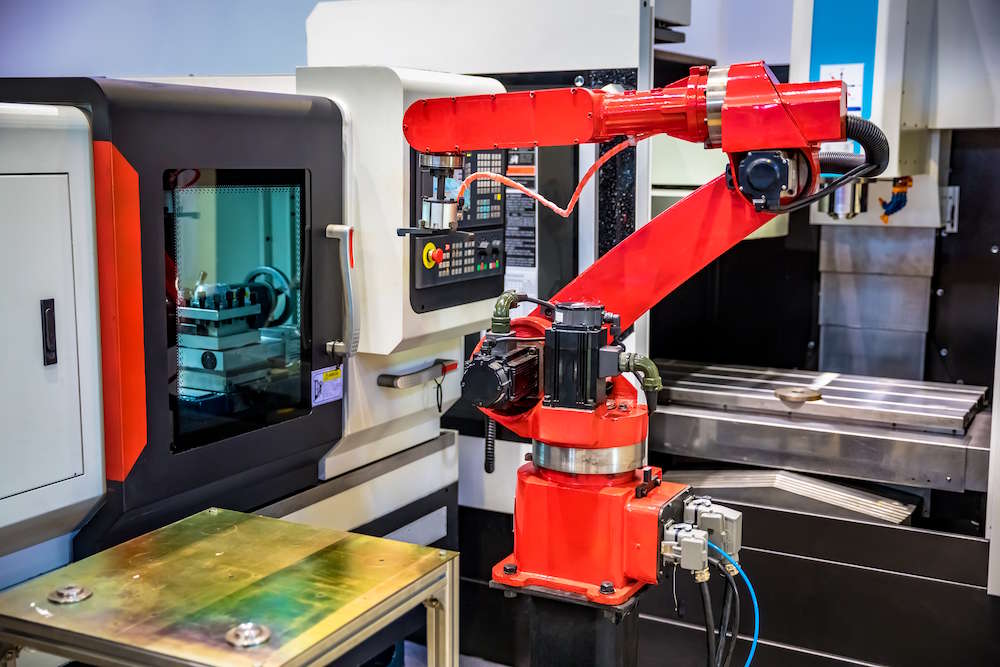 Industrial robot arm tending to industrial machinery